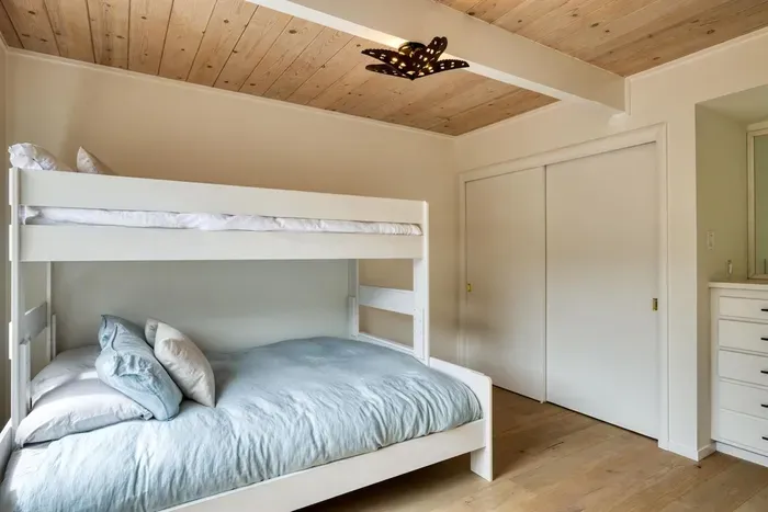 - Bunk bedroom with twin over full bed dressed in soft blue bedding  
- Wooden ceiling and white walls keep the space warm and inviting  
- Perfect for kids, friends, or additional guest accommodations