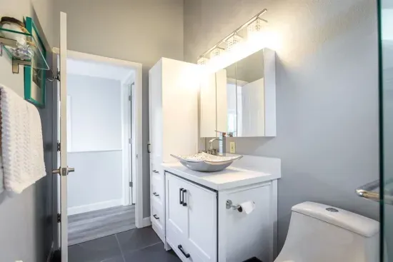 - Bright bathroom with vessel sink, sleek vanity, & mirrored storage cabinet under soft modern lighting
- Chrome fixtures & fresh white cabinetry for a clean, inviting feel
- Neutral tones and natural light create a relaxing spa inspired atmosphere