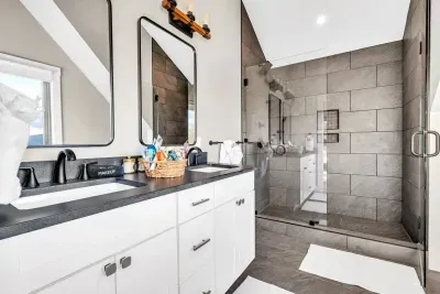 The master ensuite full bathroom, equipped with a double vanity and custom stone tile shower which offers the highest levels of luxury to guests 