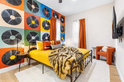 Cozy up in the king bed of this downstairs guest bedroom, accompanied by a groovy musical mural, a walk-in open closet, and a smart TV!