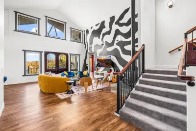 As you enter the estate, you'll be greeted by a stylishly designed and well decorated open floor plan with a massive two story custom mural and  gorgeous views of the surrounding Asheville mountains!