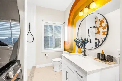 The first full bathroom on the main floor, equipped with a stylish vanity, custom tiled shower and brand new stacked washer & dryer offering the highest levels of luxury to guests.