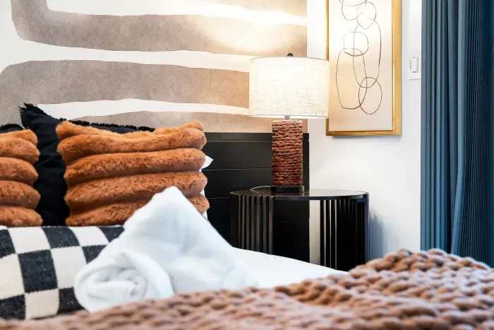 Cozy designer bedroom with plush textures, modern decor, and warm lighting