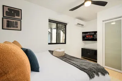 Bright modern bedroom with streaming TV, cozy bed, and minimalist style