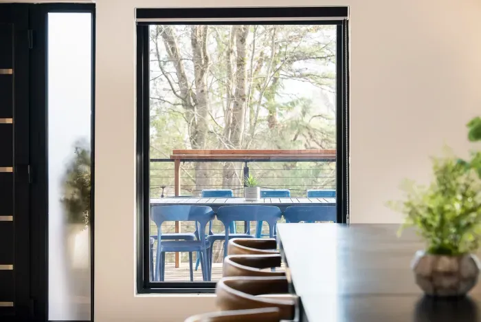 Bright dining space with tree-view deck and seamless indoor-outdoor feel