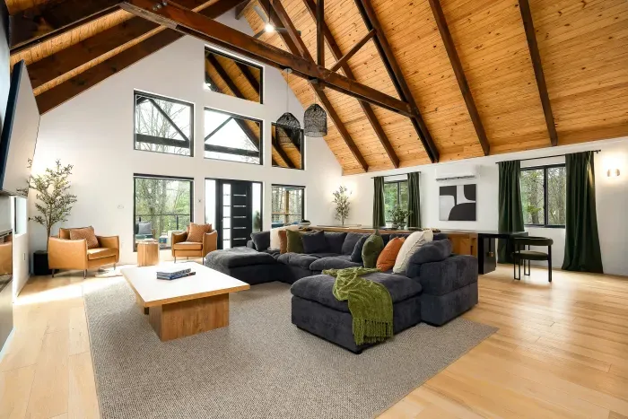 Soaring wood ceilings and a cozy oversized sectional with forest views
