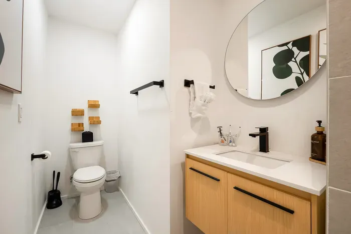 Bright modern bathroom with sleek black accents and stylish wood vanity