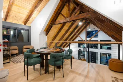Cozy loft game area with vaulted wood ceilings and card table