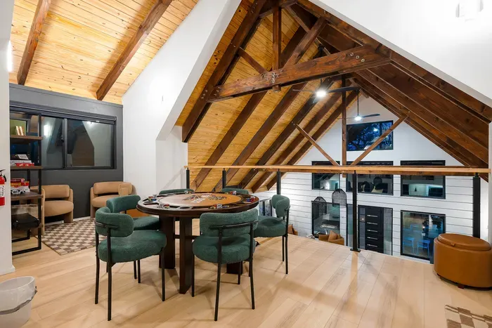 Cozy loft game area with vaulted wood ceilings and card table