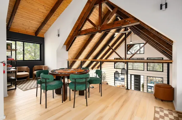 Bright loft game area with vaulted wood ceilings and scenic natural light
