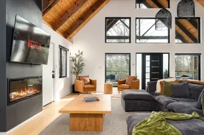 Vaulted-ceiling great room with fireplace, big windows, and cozy sectional