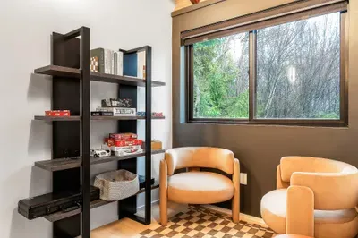 Cozy reading nook with forest views, lounge chairs, and games