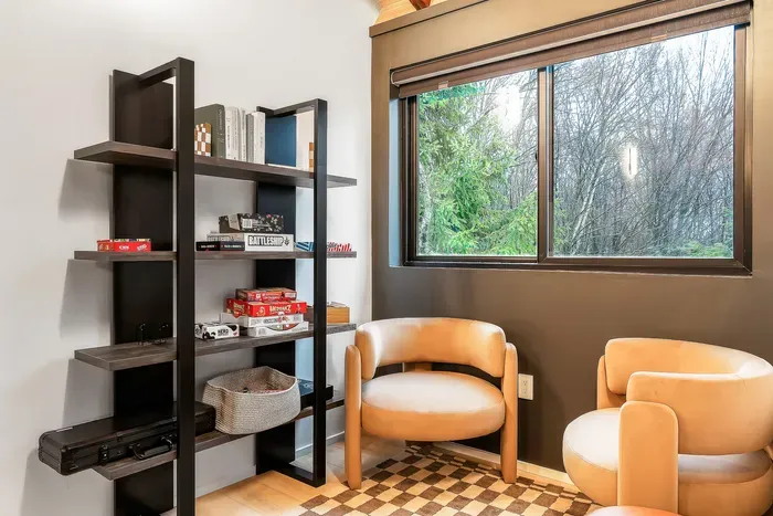 Cozy reading nook with forest views, lounge chairs, and games
