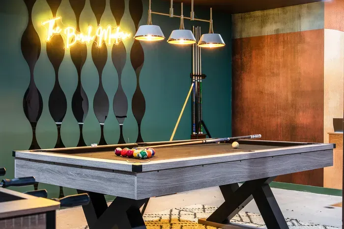 Modern game room with pool table, pendant lights, and chic lounge vibes