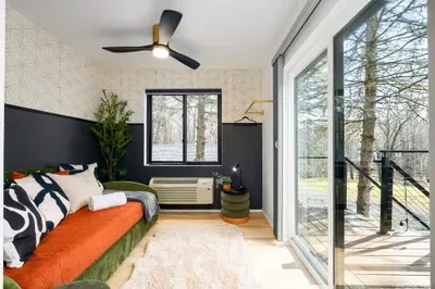 Bright modern bedroom with private deck and serene wooded views