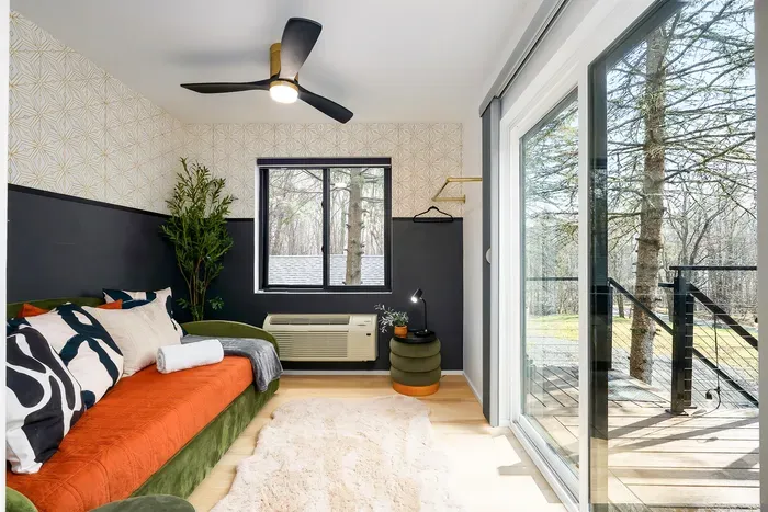 Bright modern bedroom with private deck and serene wooded views