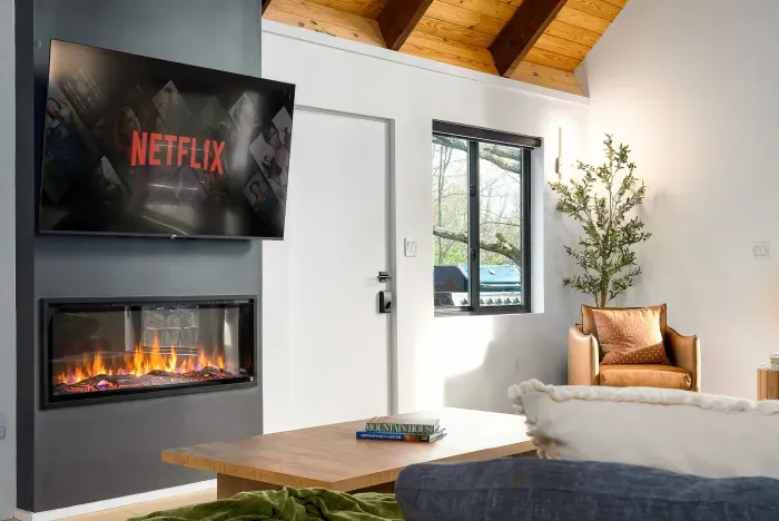 Cozy modern lounge with fireplace, vaulted ceilings, and streaming TV