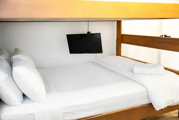 Cozy bunk room with crisp linens and a personal TV for added comfort