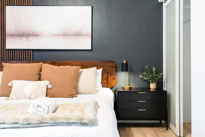 Cozy modern bedroom with designer touches and a sleek mirrored closet