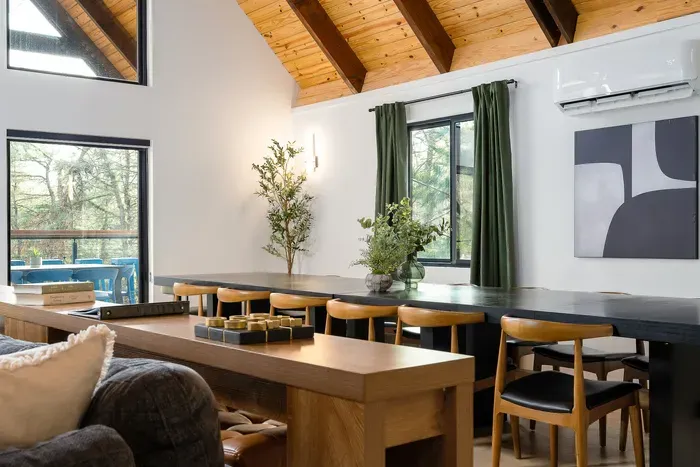 Vaulted wood ceilings and a spacious dining area with forest views