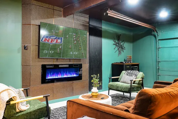Modern game-day lounge with big-screen TV, fireplace, and cozy seating