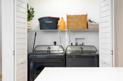 Bright in-unit laundry with full-size washer, dryer, and handy storage