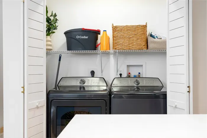 Bright in-unit laundry with full-size washer, dryer, and handy storage