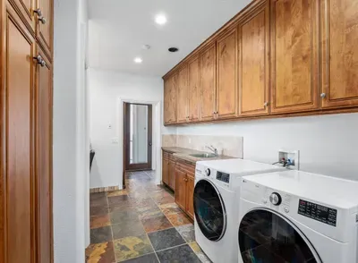 Laundry Room with washer / dryer, iron, ironing board, steamer.