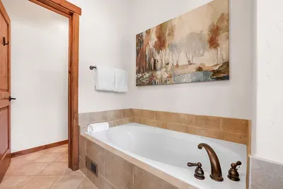 Luxurious Escape: The primary bathroom offers a spa-like experience with its expansive soaker tub and sleek walk-in shower, perfect for ultimate relaxation.