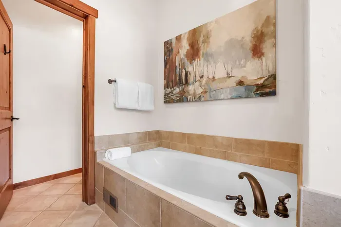 Luxurious Escape: The primary bathroom offers a spa-like experience with its expansive soaker tub and sleek walk-in shower, perfect for ultimate relaxation.