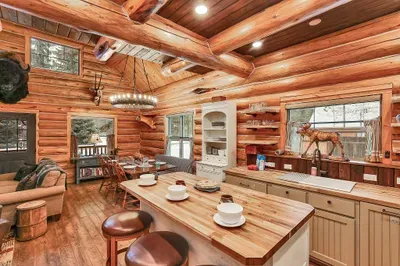 Enamel mugs, wood grain, and a well‑used cutting board give the kitchen its nostalgic, cabin‑camp feel