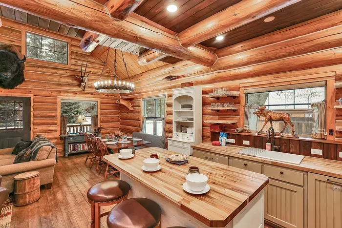 Enamel mugs, wood grain, and a well‑used cutting board give the kitchen its nostalgic, cabin‑camp feel