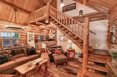 Hand‑hewn logs, vaulted ceilings, and warm light make the great room the heart of the cabin