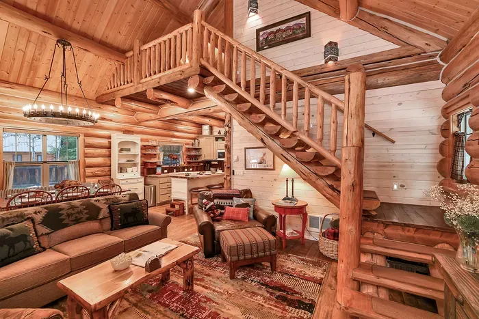 Hand‑hewn logs, vaulted ceilings, and warm light make the great room the heart of the cabin