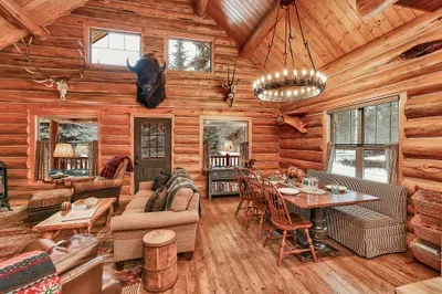 The open‑concept great room at Alder & Antler keeps everyone in the same story—cooks in the kitchen, card players at the table, and loungers by the stove