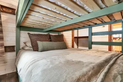 Warm wood, soft light, and sturdy bunks give this bedroom a classic camp feel, only with real mattresses and cozy cotton linens