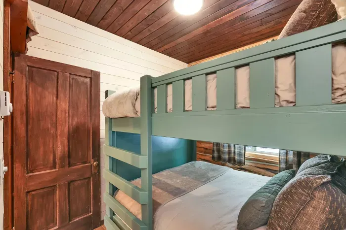 Close the door, pull the curtains, and turn the bunk room into a quiet nest after long lake days and late porch nights