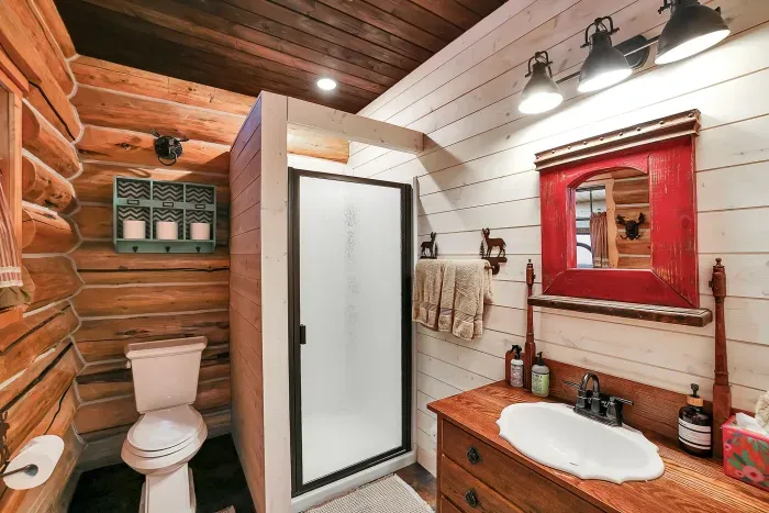 With the bunk room and great room close by, the main floor bath quietly does its job—rinsing off dusty kids and tired hikers. Hot water, soft towels, and straightforward finishes make this bathroom a no‑fuss landing spot between porch time and town