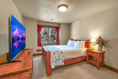 Cozy upstairs queen bedroom with lodge details and forest views, plus a walk-in closet