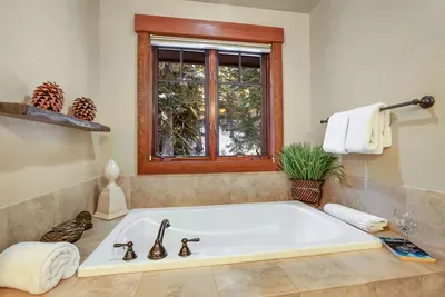 Spa-style primary bath with soaking tub and walk-in shower after a long day outside.