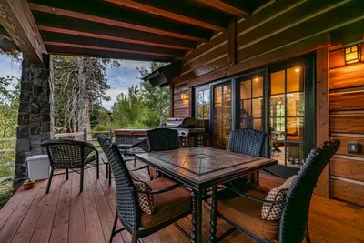 Covered back patio that feels private and tucked into the trees.