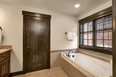 Primary ensuite bath with a big soaker tub for post-ski muscle recovery