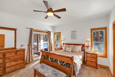 Main‑floor primary bedroom with queen bed and direct access to the deck and hot tub.