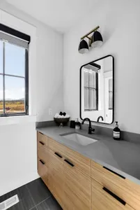 Tile, glass, warm towels—clean, simple, and easy to share. Full bath with walk-in shower across from the bunk room