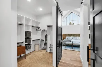 Private retreat on the main floor, offering easy access to all the villa's amenities. With a dual-sided walk-in closet, expansive ensuite bathroom, king bed, and patio access