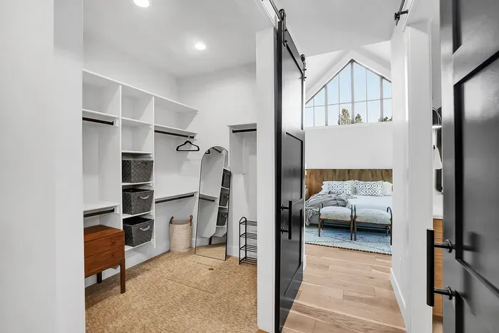 Private retreat on the main floor, offering easy access to all the villa's amenities. With a dual-sided walk-in closet, expansive ensuite bathroom, king bed, and patio access