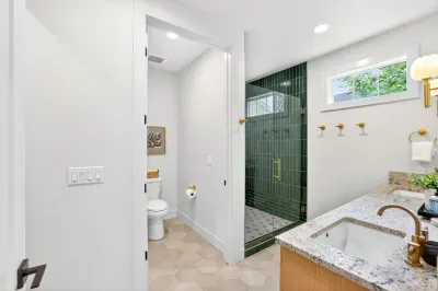 Ensuite bath for the second king suite features a walk-in, glass-enclosed tiled shower and double vanity—hotel-level comfort just steps from the bedroom.