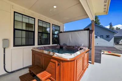 Private hot tub is just steps from the patio door, making winter soaks and cool summer evenings equally inviting.