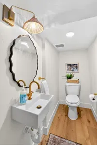 Main-floor powder room just off the great room—quietly tucked away yet conveniently central, with vintage‑inn finishes and modern fixtures so guests don’t have to wander through the private bedroom suites.