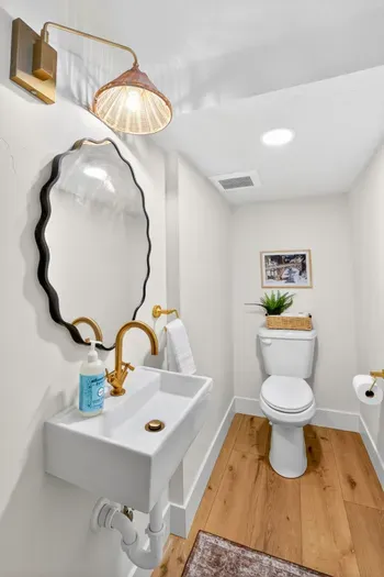 Main-floor powder room just off the great room—quietly tucked away yet conveniently central, with vintage‑inn finishes and modern fixtures so guests don’t have to wander through the private bedroom suites.